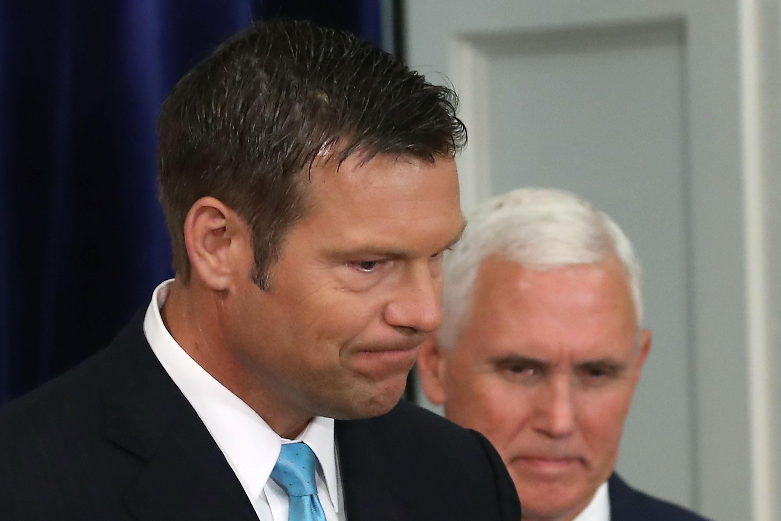 WASHINGTON, DC - JULY 19: Kansas Secretary of State, Kris Kobach (L) and US Vice President Mike Pence, attend the first meeting of the Presidential Advisory Commission on Election Integrity in the Eisenhower Executive Office Building, on July 19, 2017 in Washington, DC.  (Photo by Mark Wilson/Getty Images)