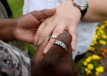 A lesbian couple exchanges wedding rings.