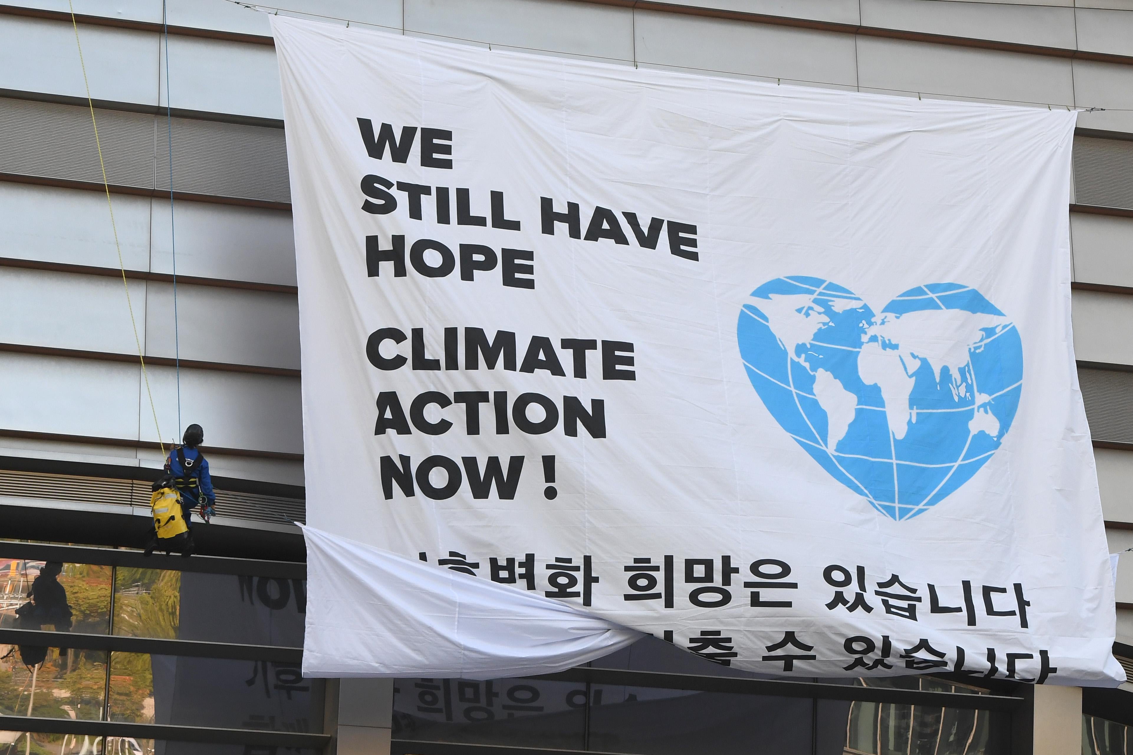 Greenpeace activists display a big banner reading "We still have hope, Climate action now!" during an activity prior to a press conference of the Intergovernmental Panel for Climate Change (IPCC) at Songdo Convensia in Incheon on October 8, 2018. 