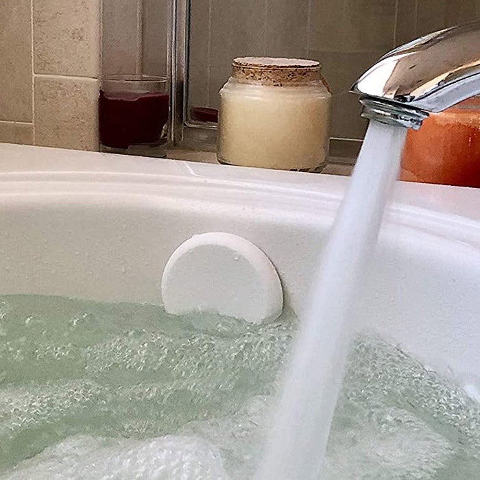 A full bath tub with a drain cover.