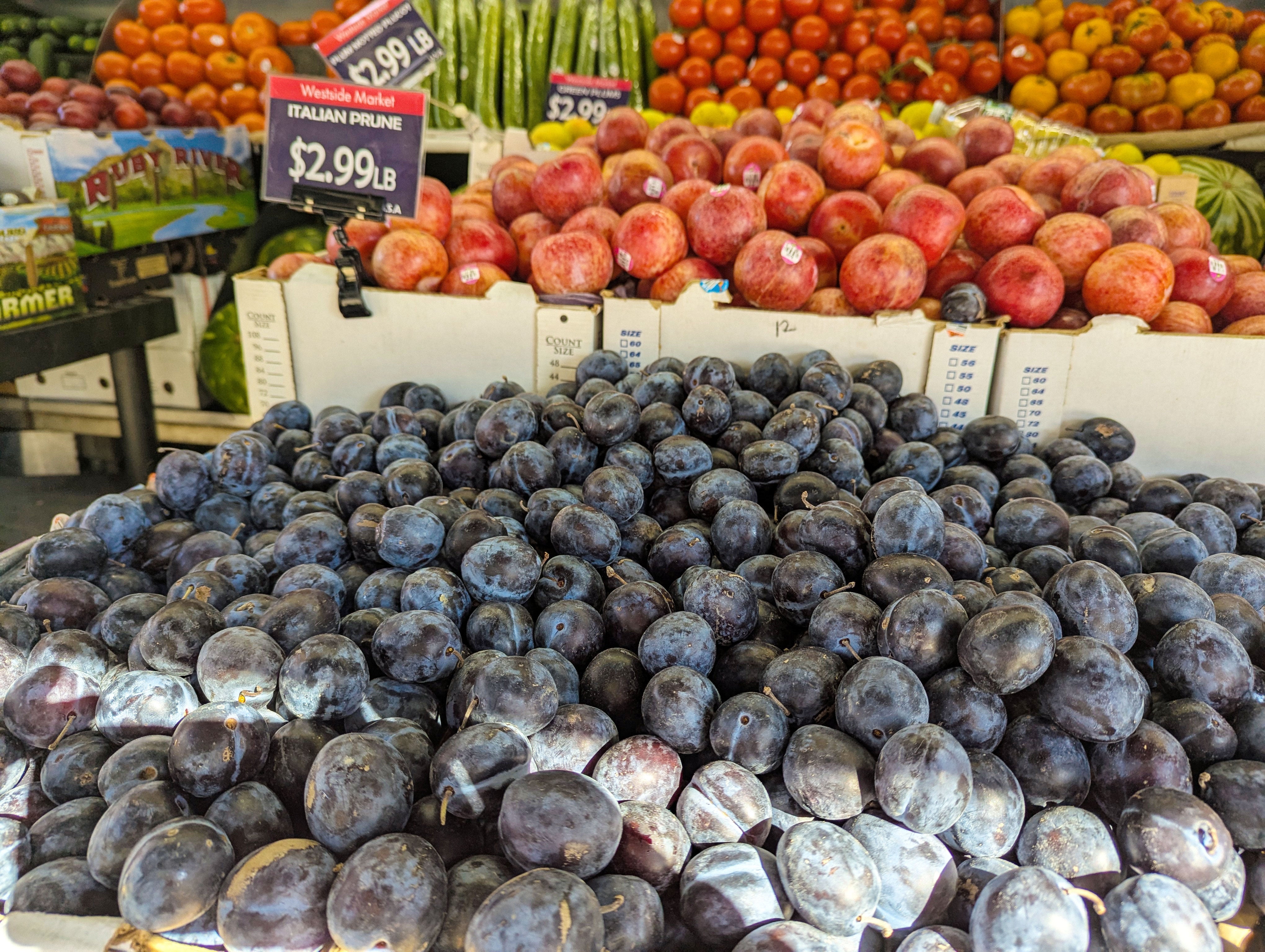A market scene of tons of plums and other stone fruit. 