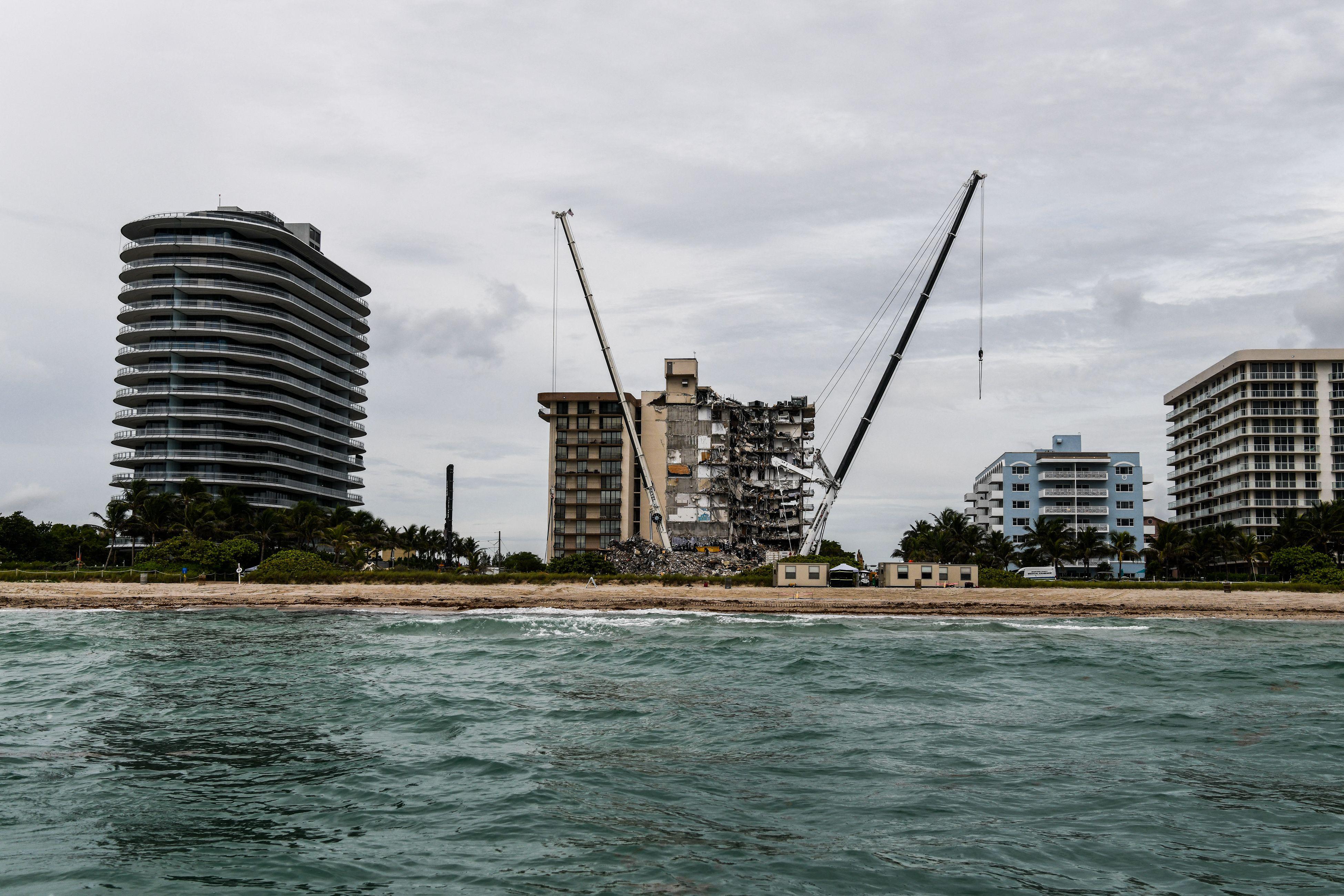 The partially collapsed Champlain Towers South condo between other condo buildings on the oceanfront seen from the water