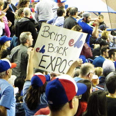A fan holds a sign reading, "Bring Back Expos."