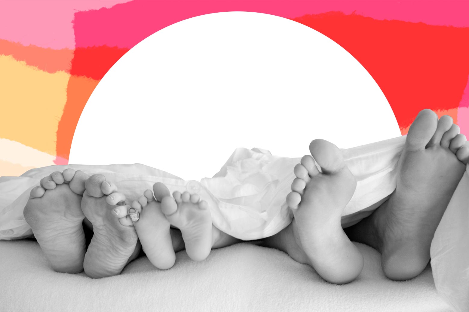 The feet of a woman, a man, and their child, as seen from the foot of their bed.