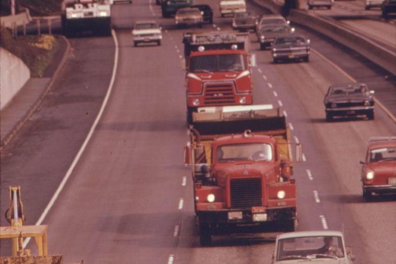 Trucks seen driving on a highway in 1974.
