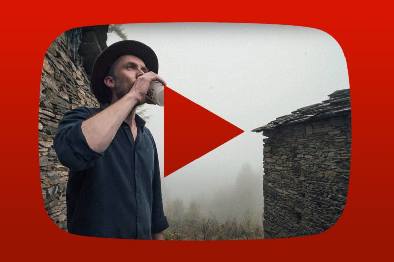 A man stands between two rustic structures made of layered stone. A YouTube "play" icon is visible in the picture.
