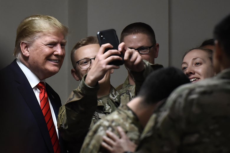 President Donald Trump poses for selfies during a Thanksgiving dinner with US troops at Bagram Air Field during a surprise visit on November 28, 2019 in Afghanistan. 