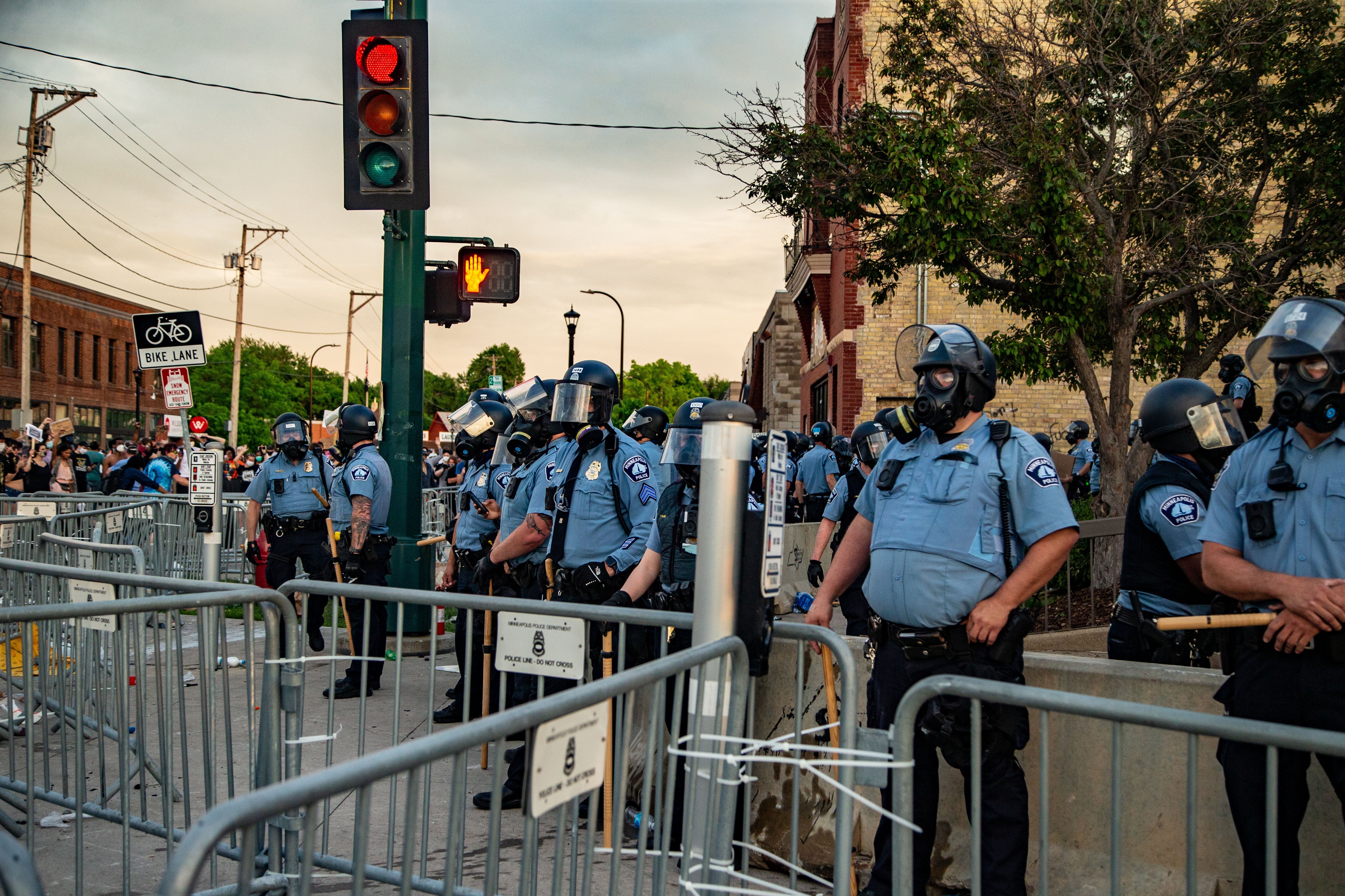 Police in masks stand near barricades and traffic lights.