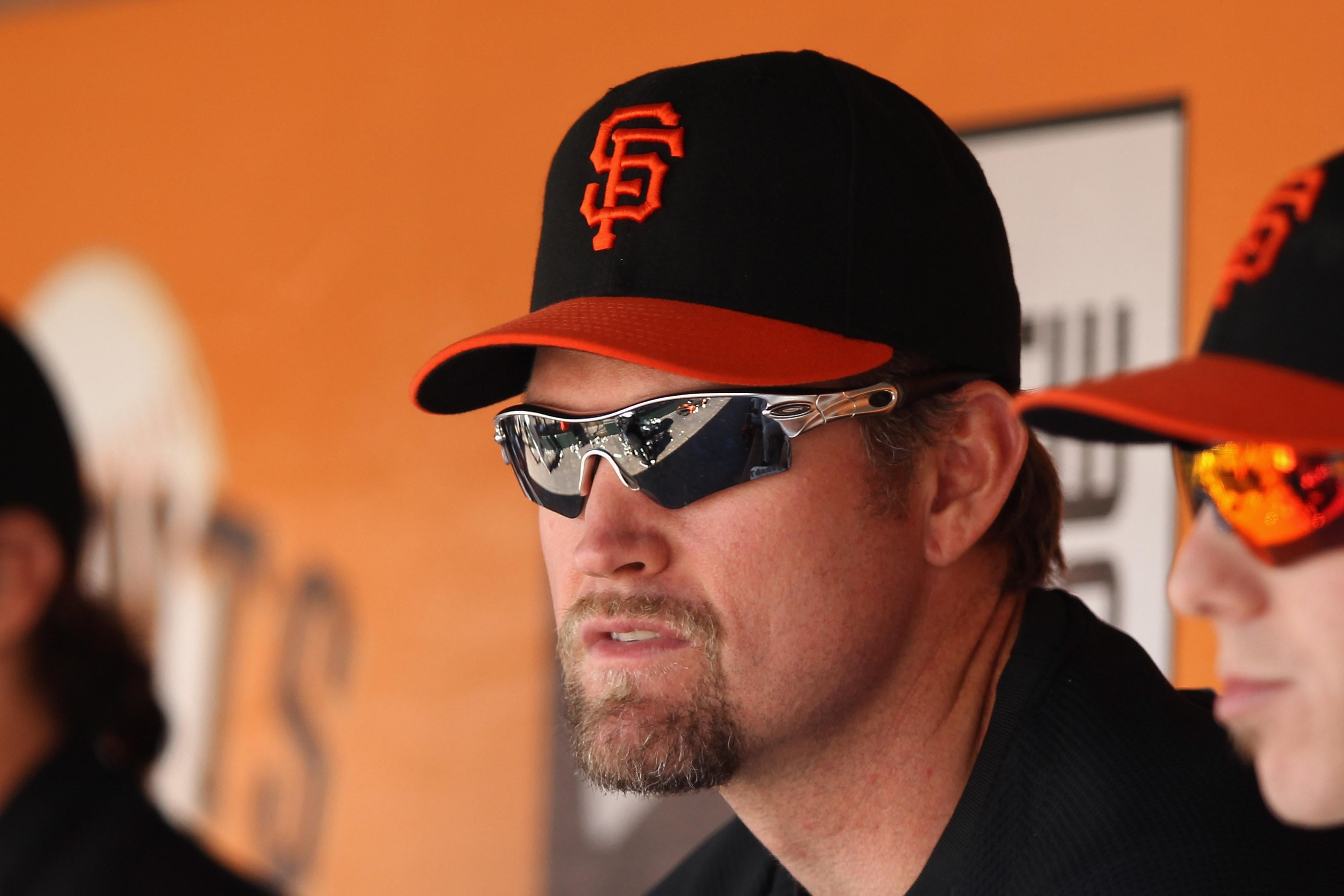 Aubrey Huff and Tim Lincecum sitting in the dugout in their Giants hats and wraparound sunglasses.