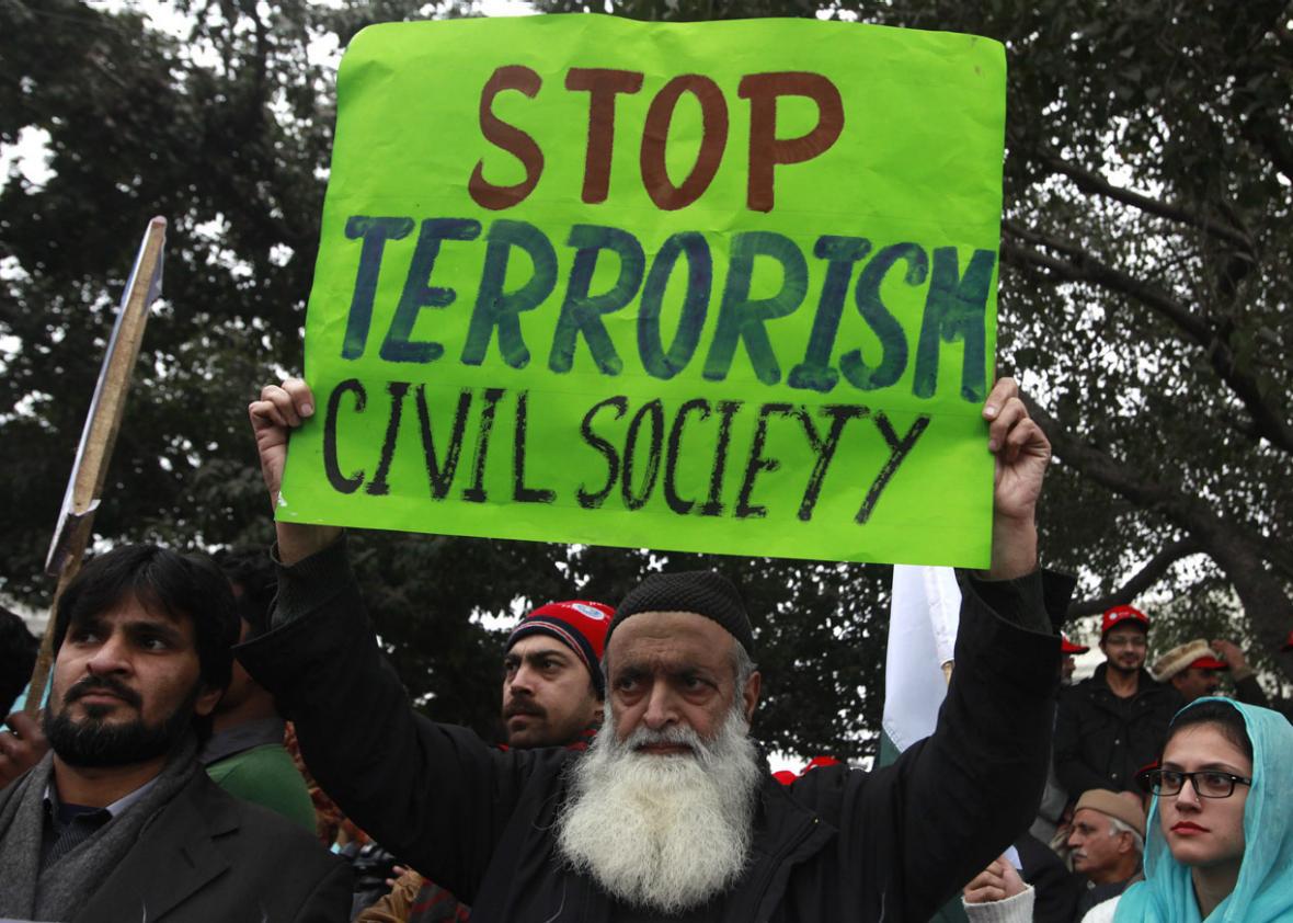 A man holds an anti-Taliban sign along with others during a peace rally in Lahore on January 5, 2015. 