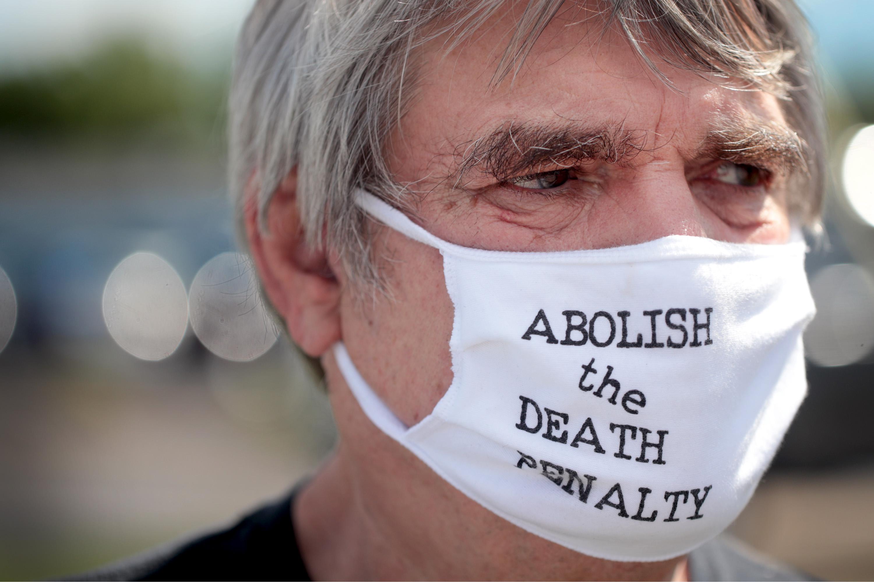 Pelke wears a mask that reads "Abolish the death penalty."