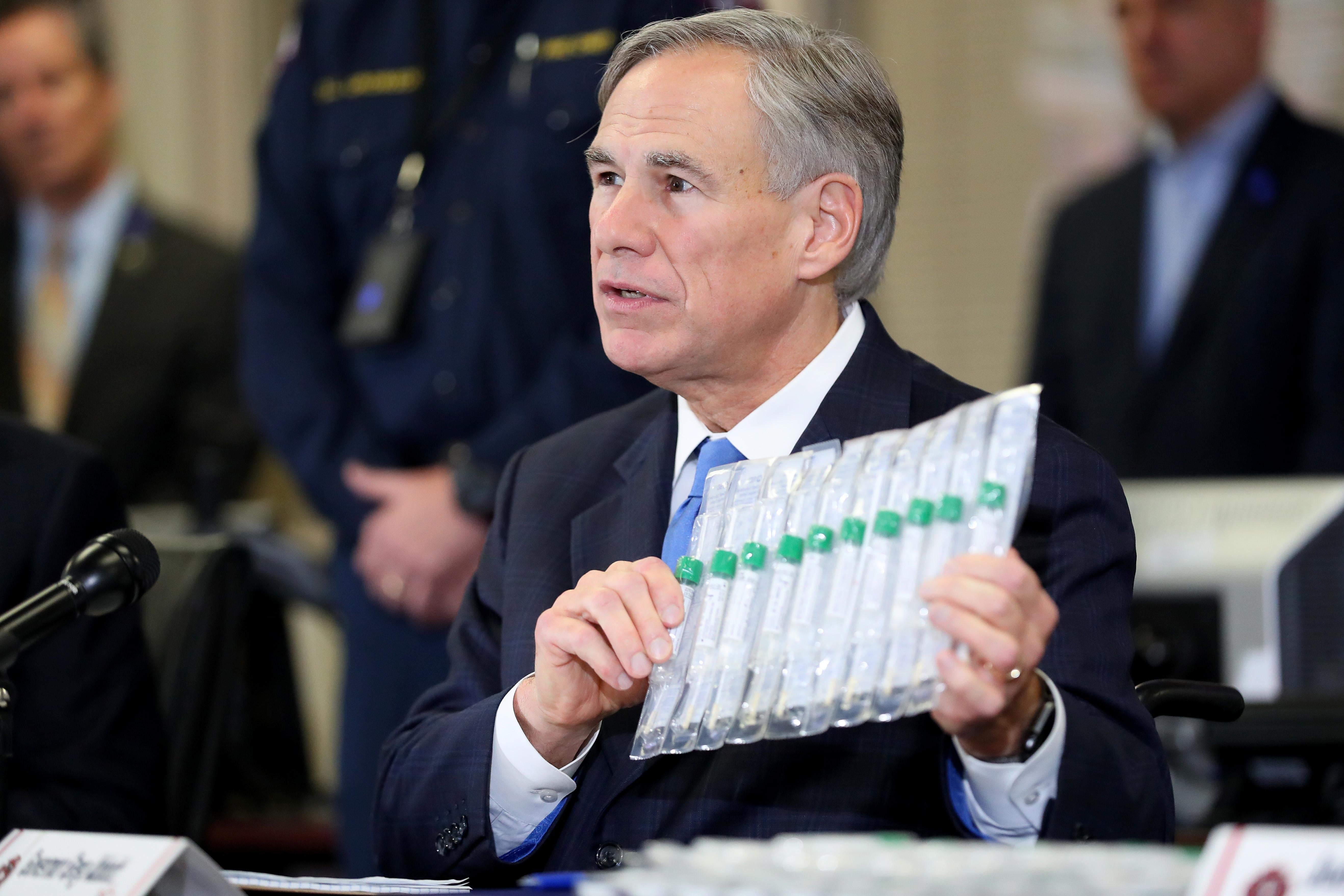 Texas Governor Greg Abbott displays COVID-19 test collection vials as he addresses the media during a press conference held at Arlington Emergency Management on March 18, 2020 in Arlington, Texas. 