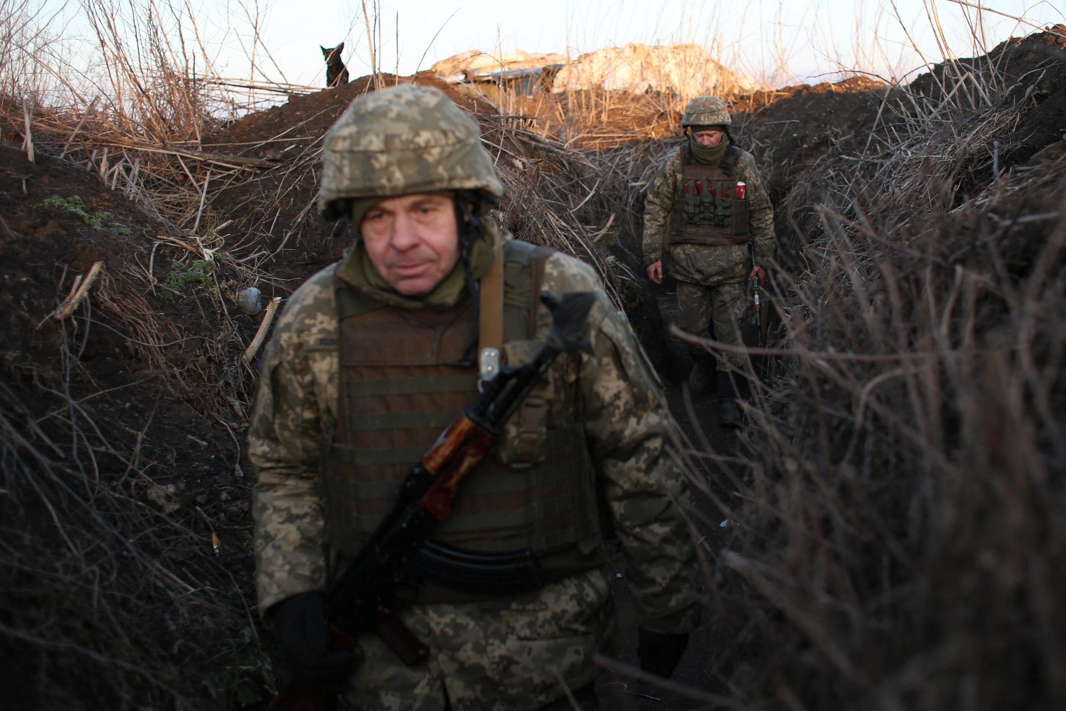 Servicemen of Ukrainian Military Forces walk along tranches on their position on the front line with Russia backed separatists, near Novognativka village, Donetsk region on February 21, 2022. 