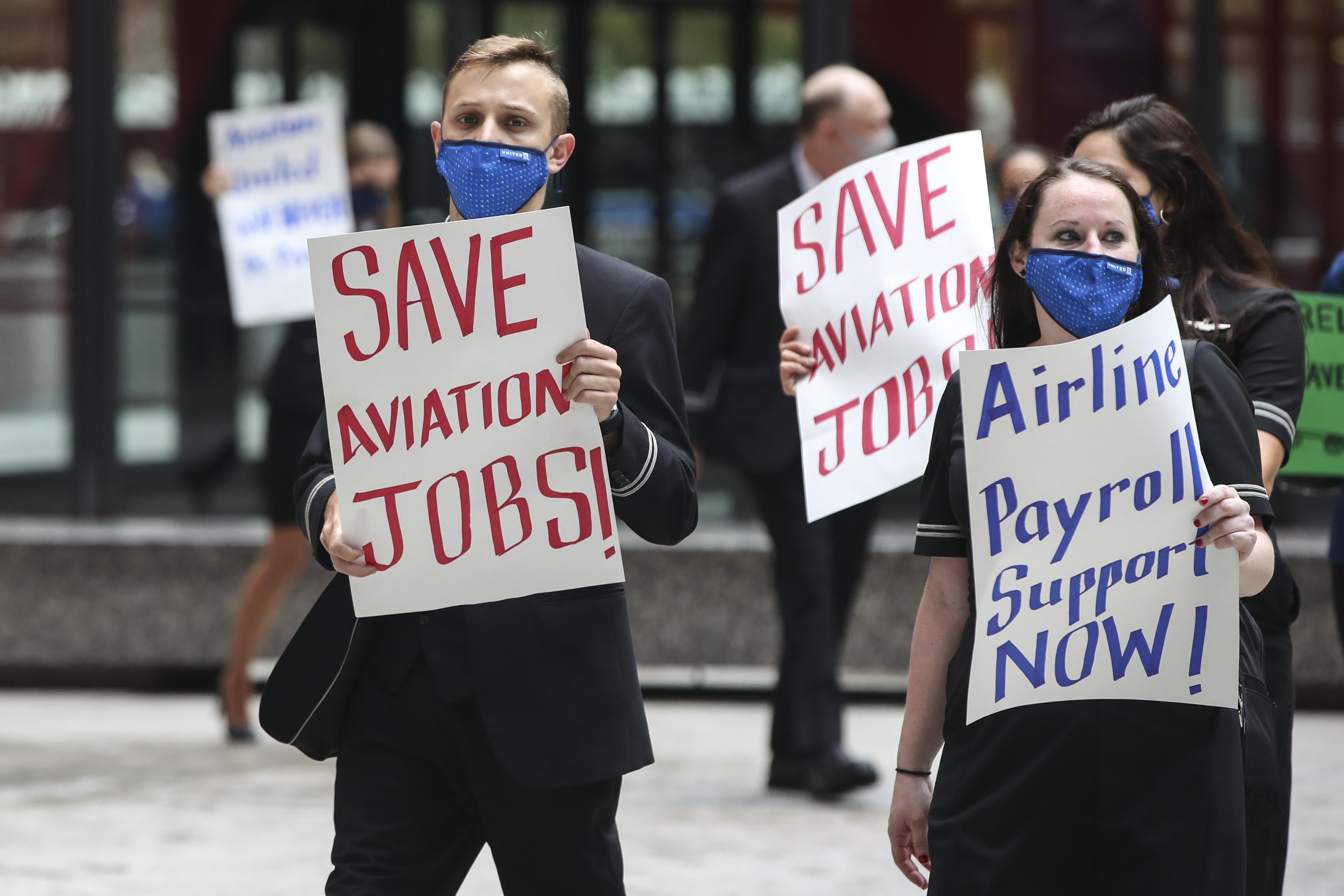 Protesters hold up signs that say "SAVE AVIATION JOBS" and "Airline Payroll Support Now!"