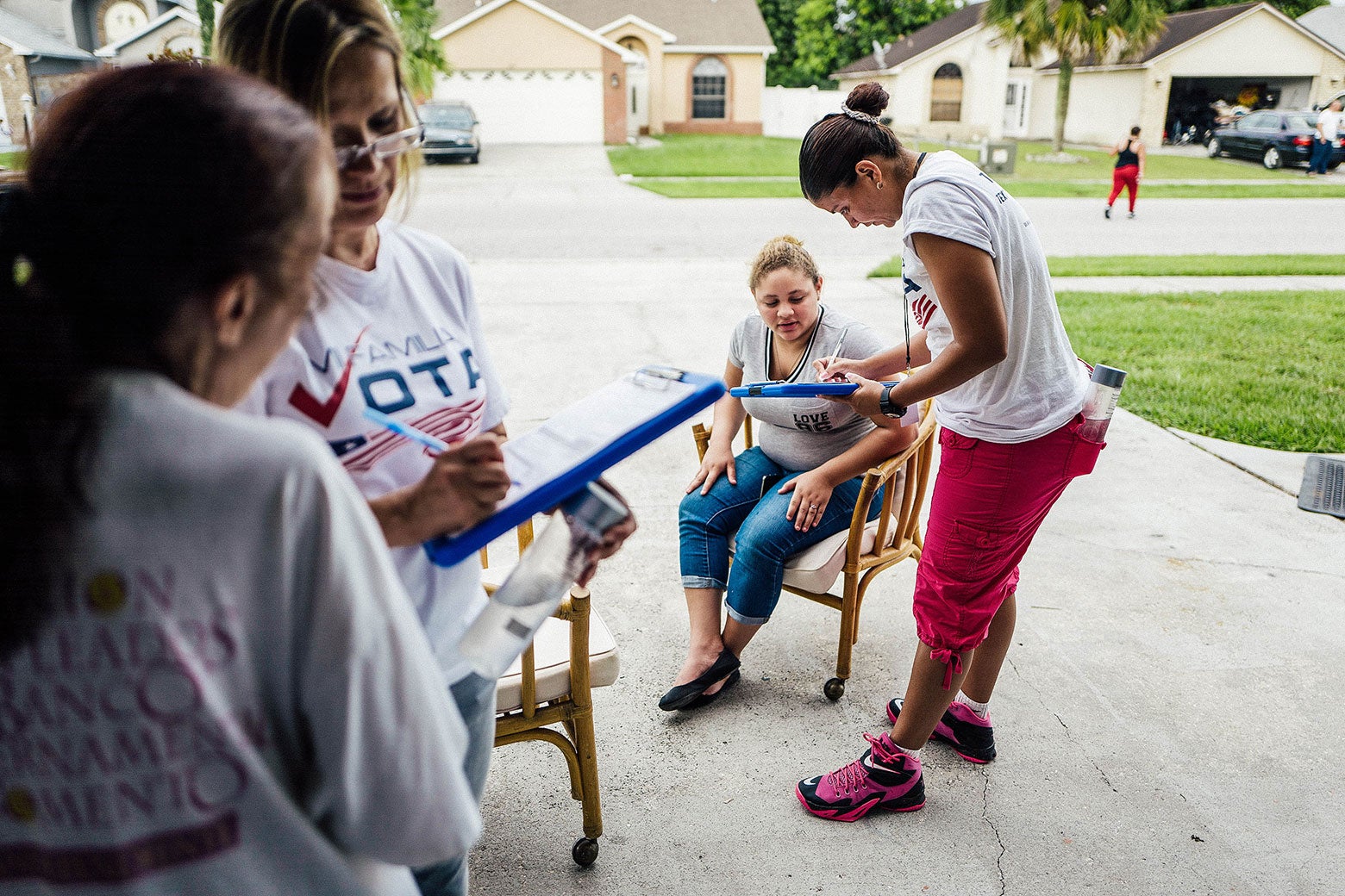 A group from Mi Familia Vota registering people to vote in a driveway.