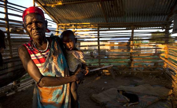 A woman holds her grandson, poor family living in a small shack in the city center July 19, 2012 in Juba, South Sudan. 