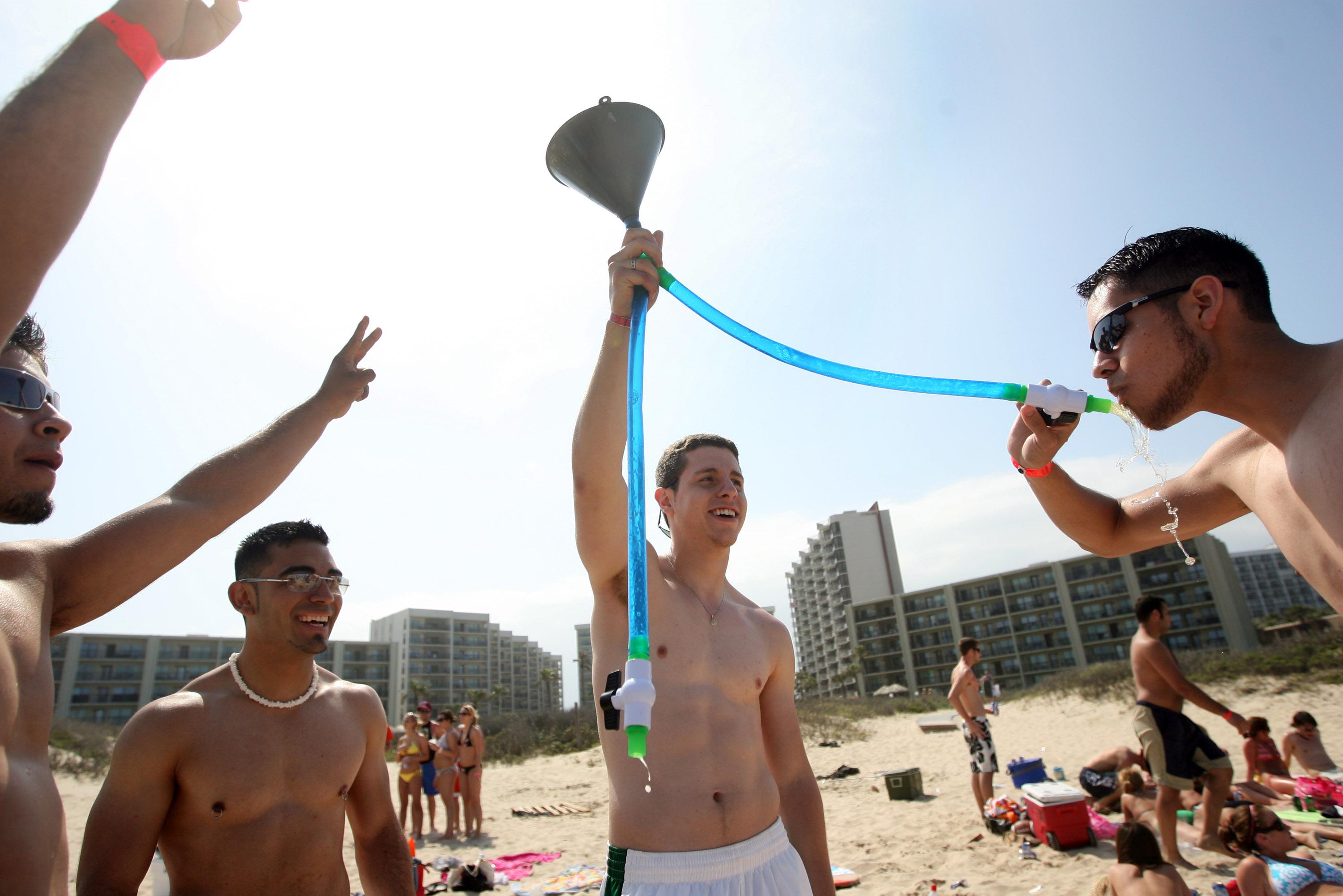 Students from the University of Texas-El Paso drink beer from a funnel on the beach during the annual ritual of Spring Break March 25, 2008, on South Padre Island, Texas.