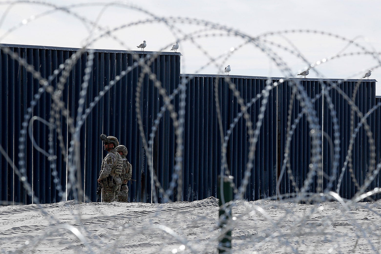 U.S. Border Patrol officers stand guard beside the border wall in Imperial Beach, California on Nov. 15.