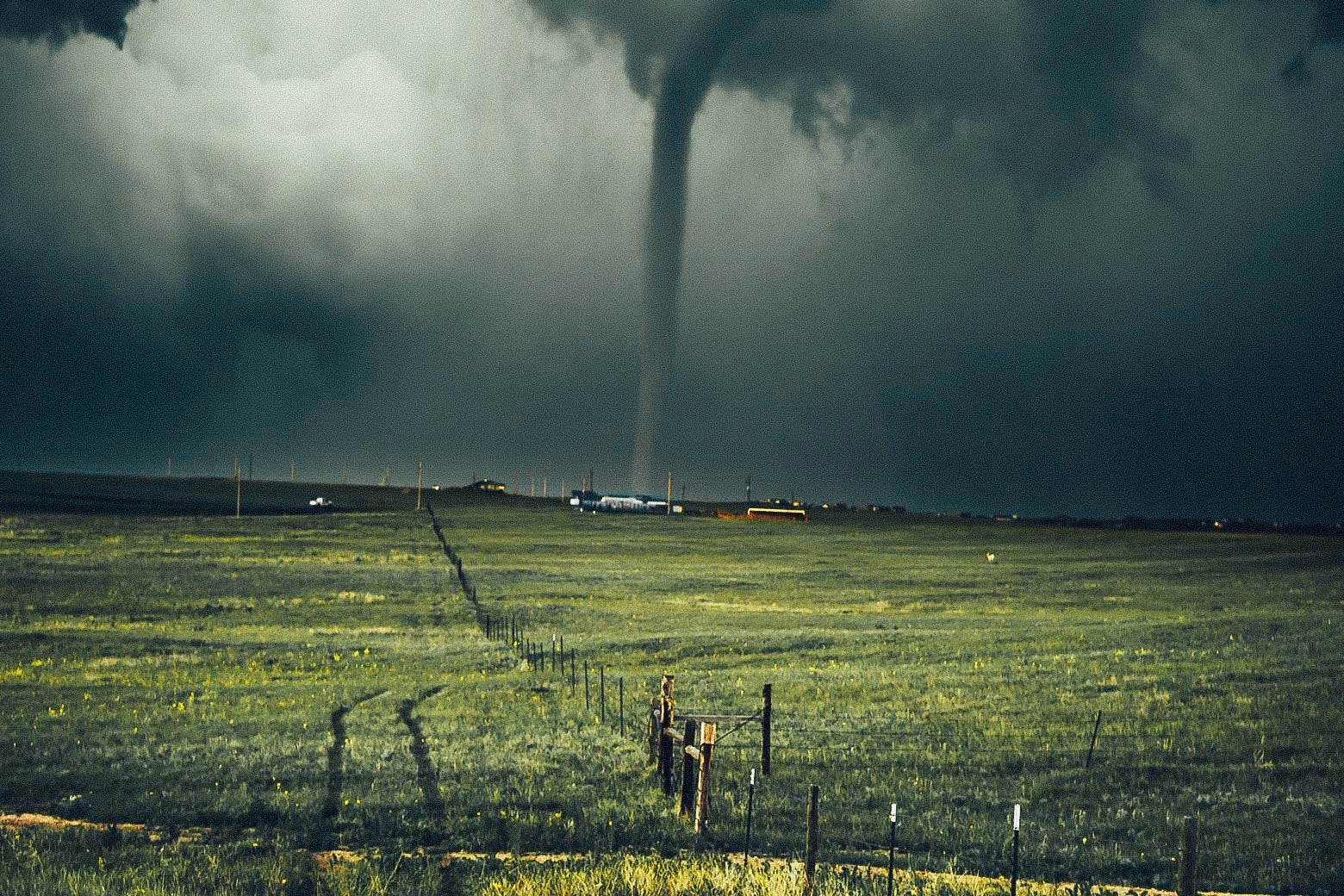 A tornado touches down near a field.