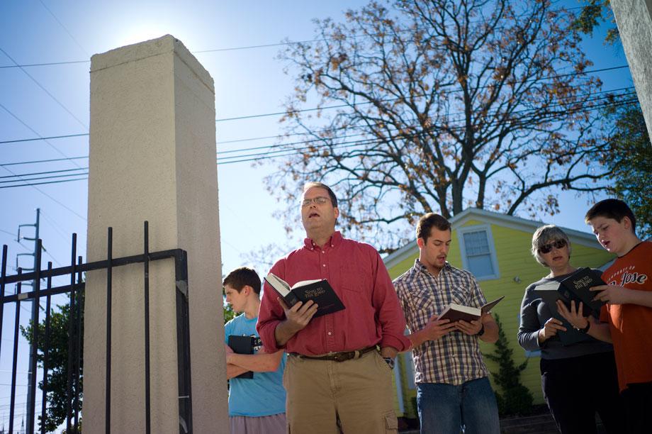 Matt Friedeman, a professor at Welsey Biblical Seminary, sings outside the clinic gates as women arrive for a counseling session in November 2012. 