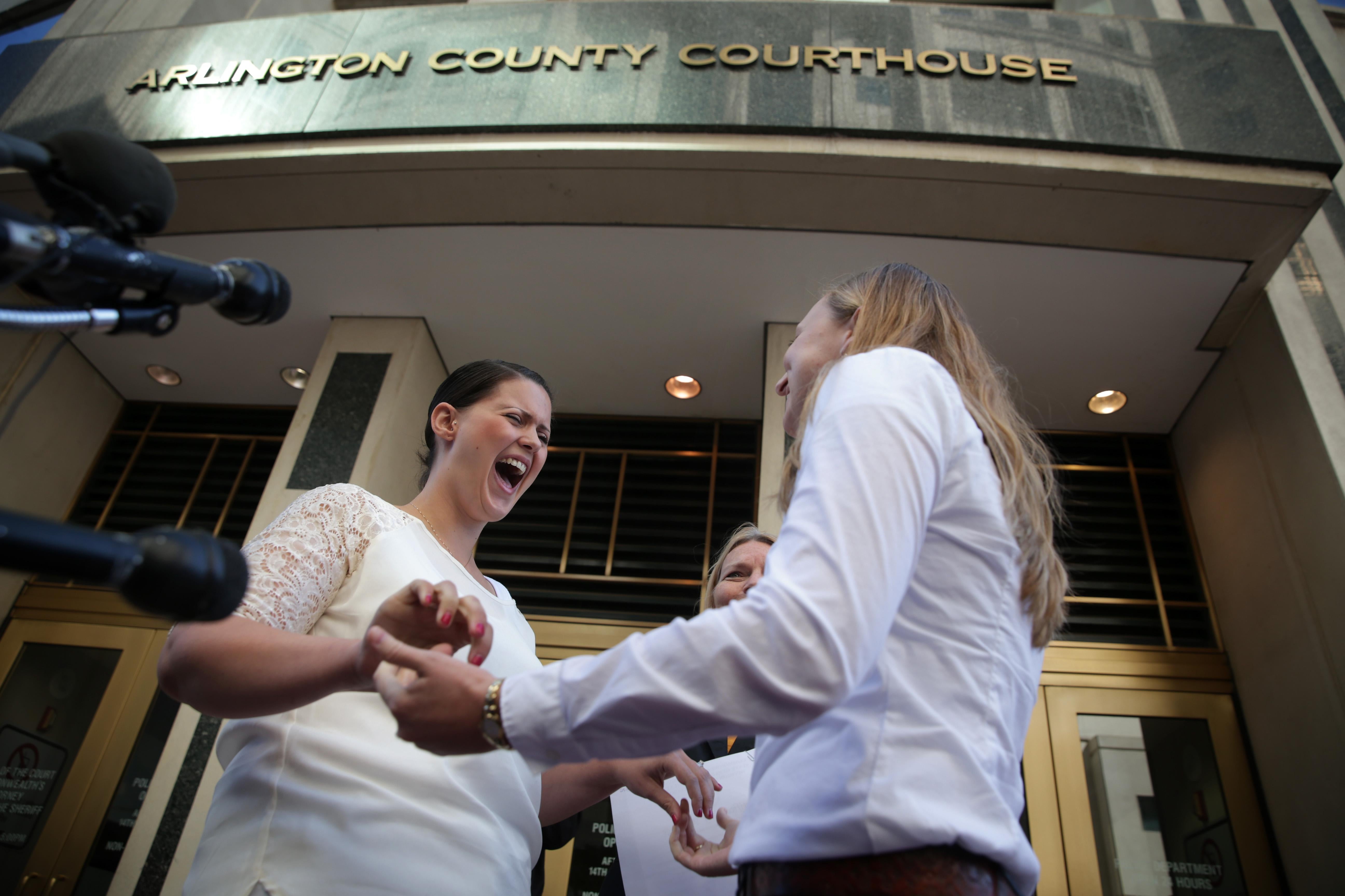 Two women get married outside a courthouse and look extremely happy.