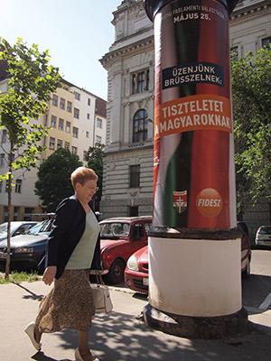 A woman in downtown Budapest walks by a European Parliament campaign poster for the Fidesz party that reads: “Our message to Brussels: Respect Hungarians!”