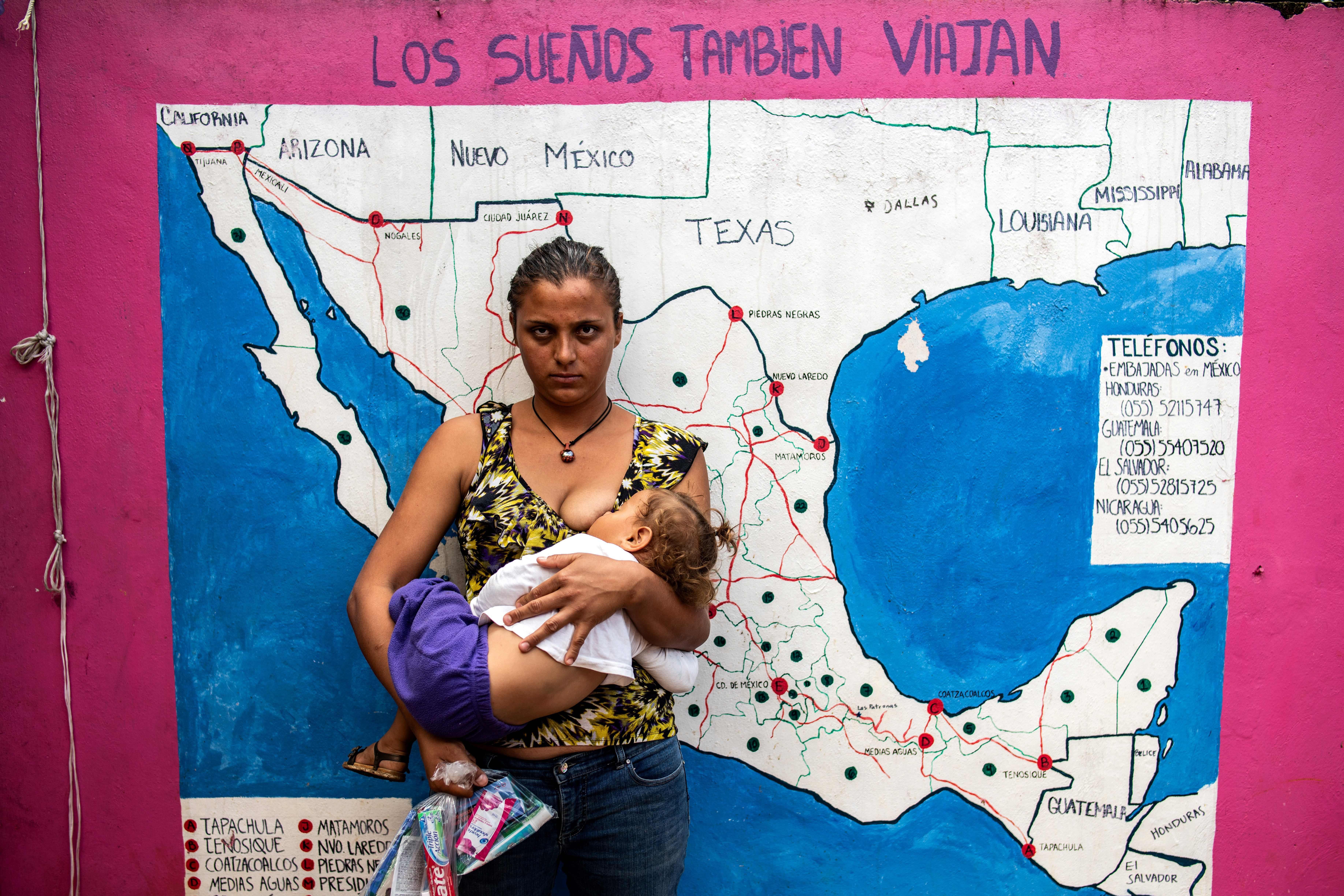 A migrant woman nurses her baby in front of a map of Mexico and the U.S. at a shelter for migrants without documents in Las Patronas town, Veracruz State, Mexico on August 10, 2018.
