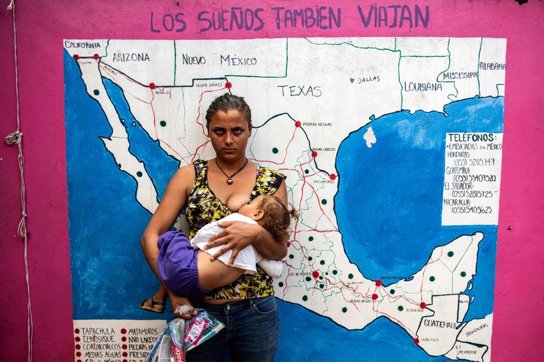 A migrant woman nurses her baby in front of a map of Mexico and the U.S. at a shelter for migrants without documents in Las Patronas town, Veracruz State, Mexico on August 10, 2018.