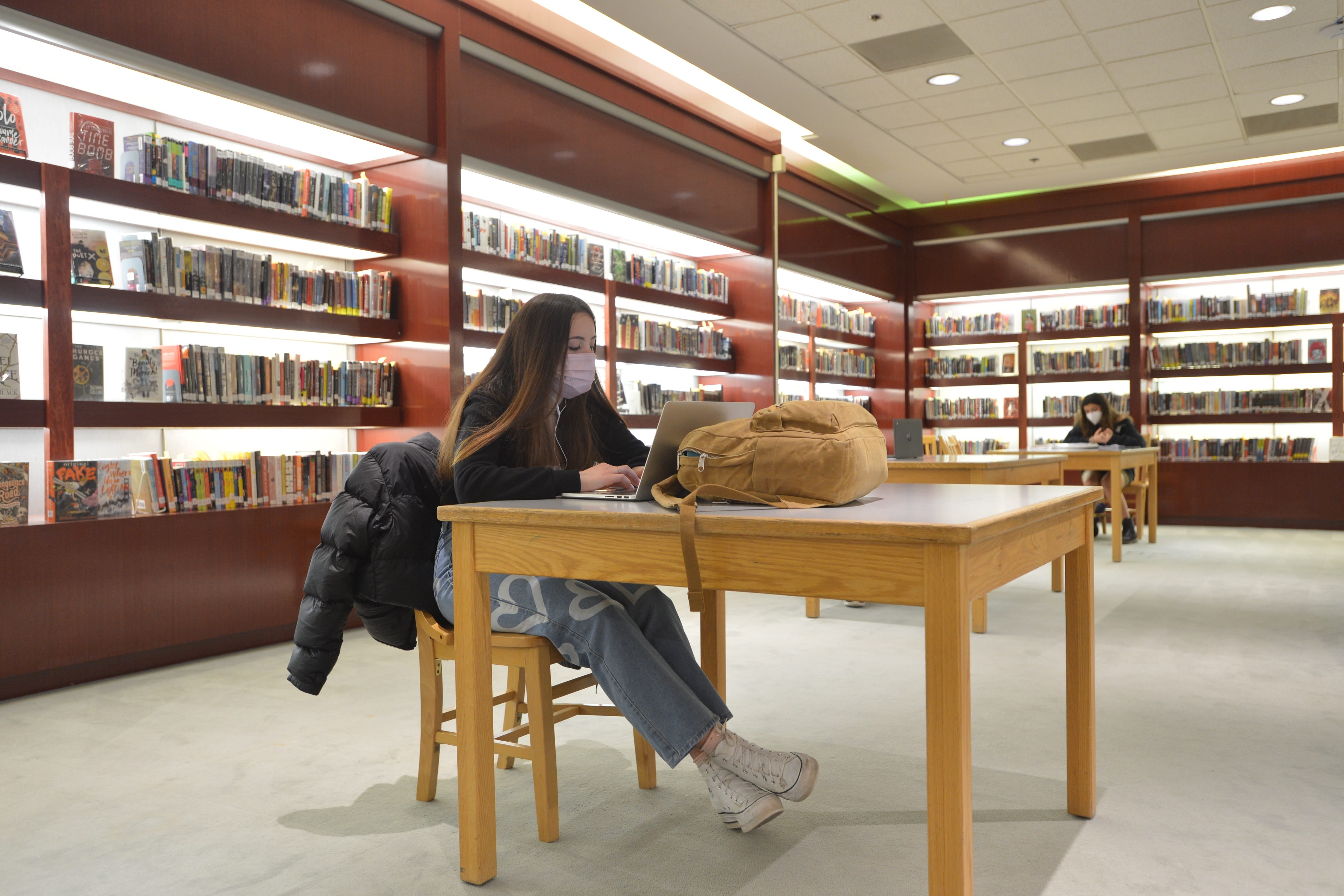 Backlit display shelves highlight reading in way not previously utilized. The area was the perfect location for Burlington High School's library when it transitioned to its temporary space in a former Macy's department store in downtown Burlington