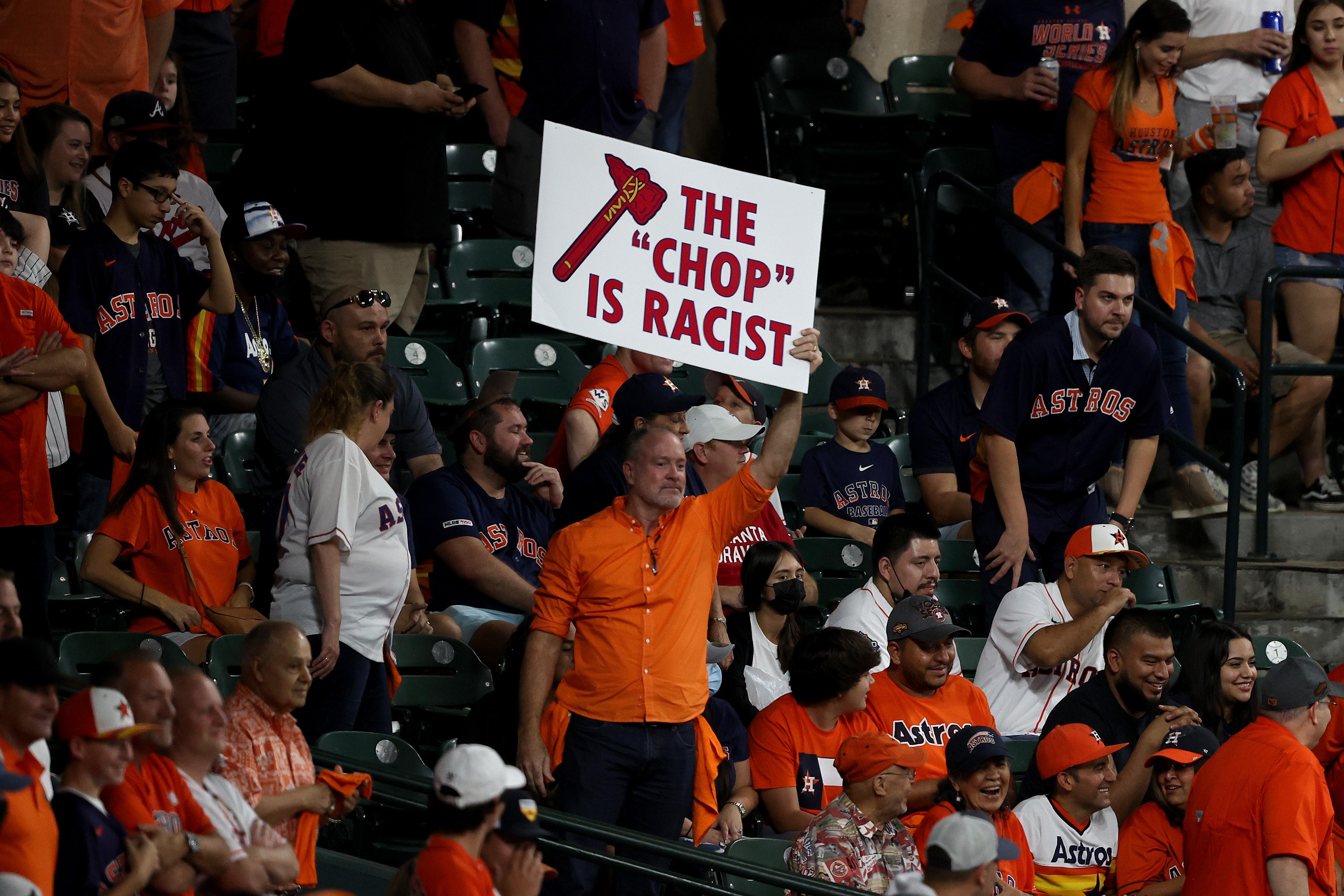 A fan holds a sign stating "the chop is racist."