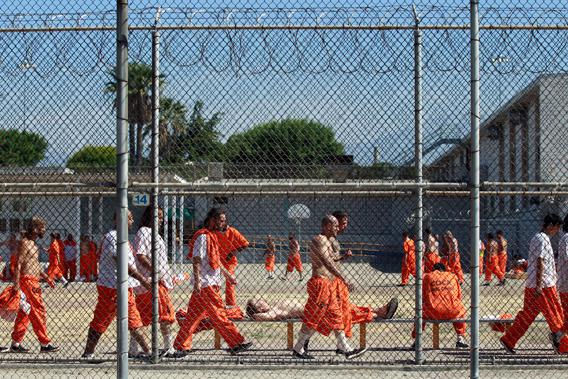 Inmates walk around an exercise yard at the California Institution for Men state prison in Chino, California, June 3, 2011. The Supreme Court has ordered California to release more than 30,000 inmates over the next two years or take other steps to ease overcrowding in its prisons to prevent "needless suffering and death." 