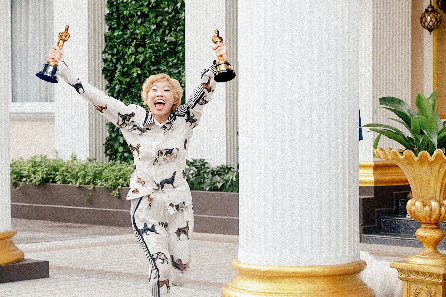 Photo illustration of Awkwafina in Crazy Rich Asians, but she's dual-wielding Oscar trophies.