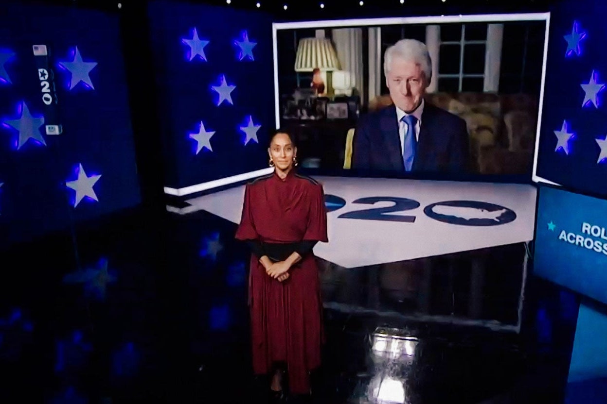 Bill Clinton looming over Tracee Ellis Ross's shoulder on a screen.