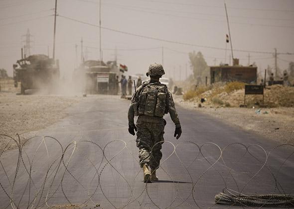 A U.S. soldier walks through a flash checkpoint set up in response to the killing of two U.S. soldiers in a car bomb.