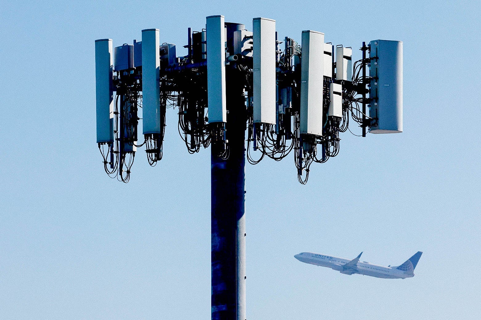 A plane flying by a cellular tower