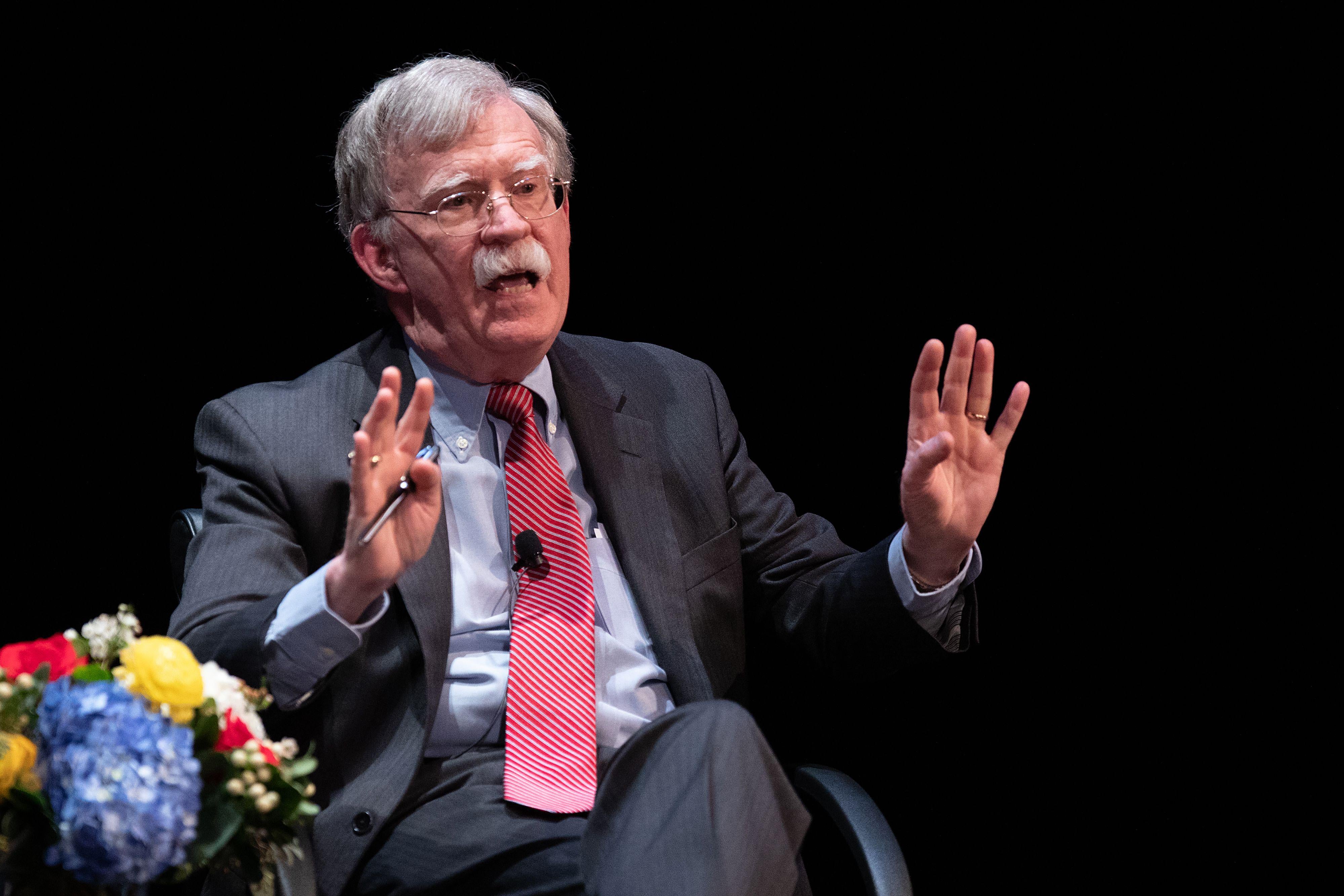 Bolton speaks while seated onstage.