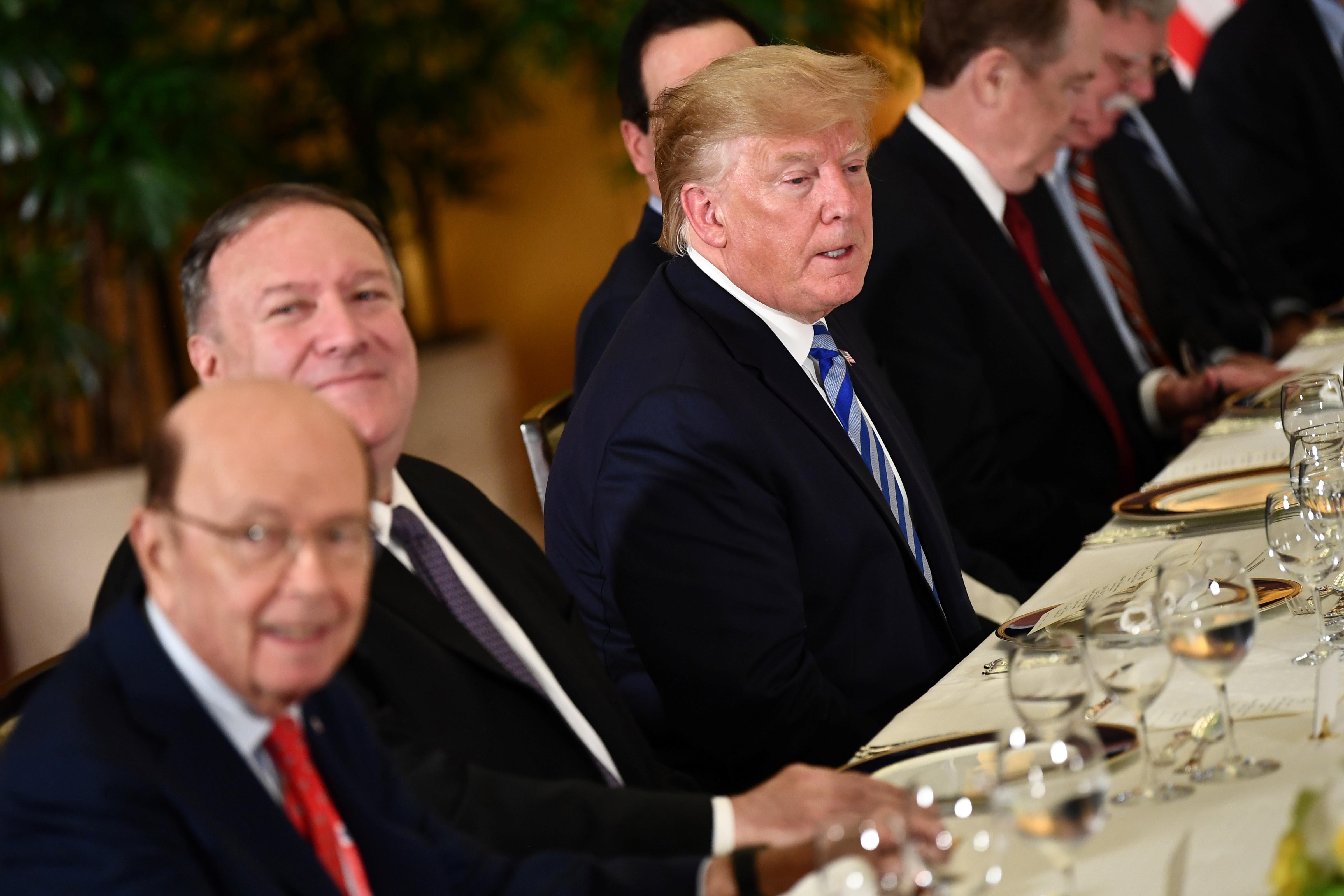 President Donald Trump sits with Secretary of State Mike Pompeo and Secretary of Commerce Wilbur Ross at a dinner.