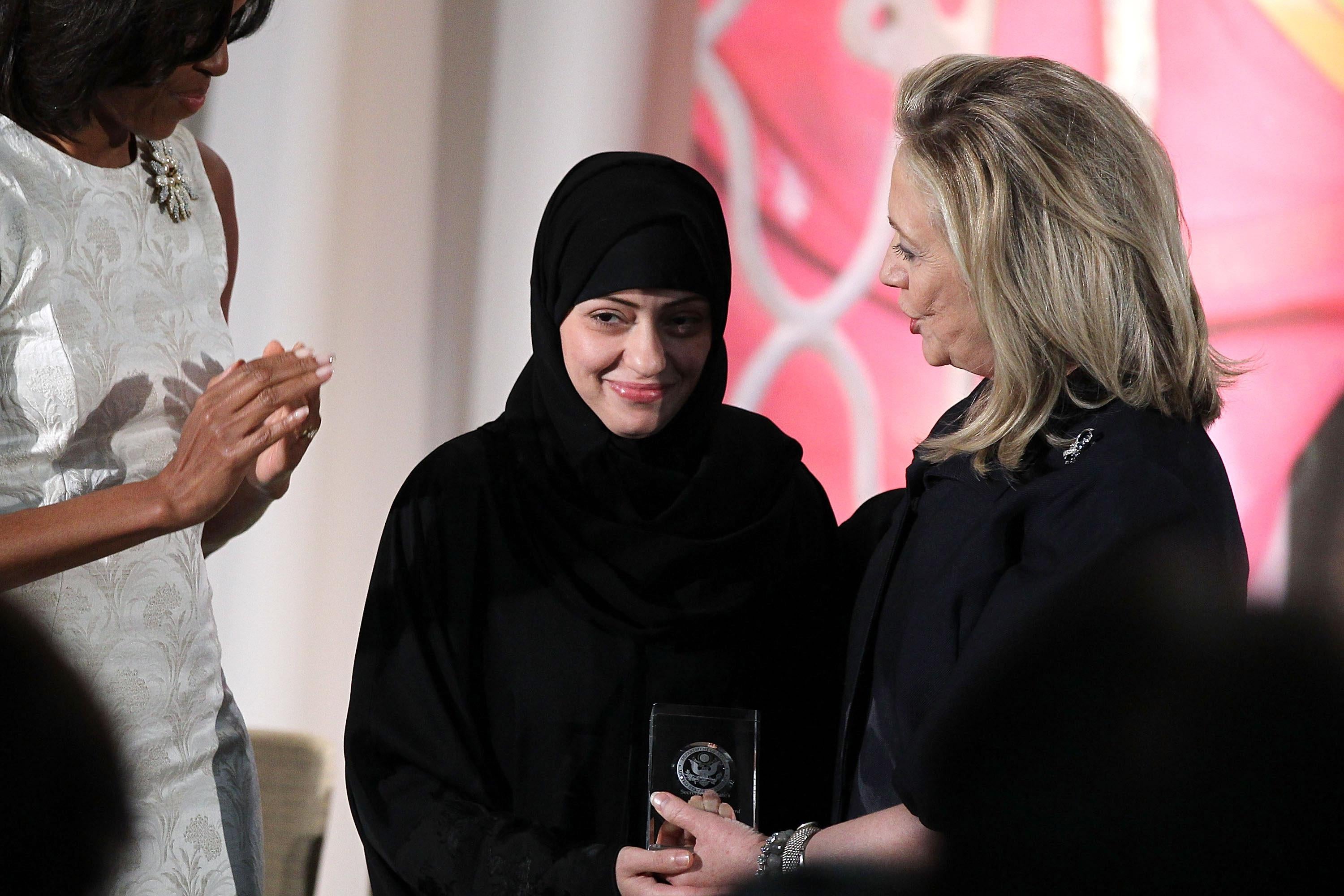Political activist Samar Badawi is presented with an International Women of Courage Award by U.S. Secretary of State Hillary Clinton as first lady Michelle Obama looks on during a ceremony at the State Department March 8, 2012 in Washington, DC. 