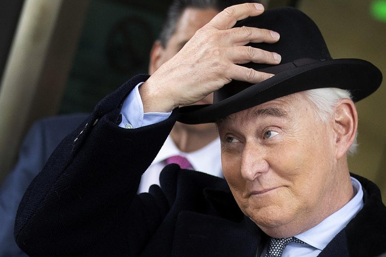 Roger Stone grins widely and grips his hat as he leaves his sentencing.