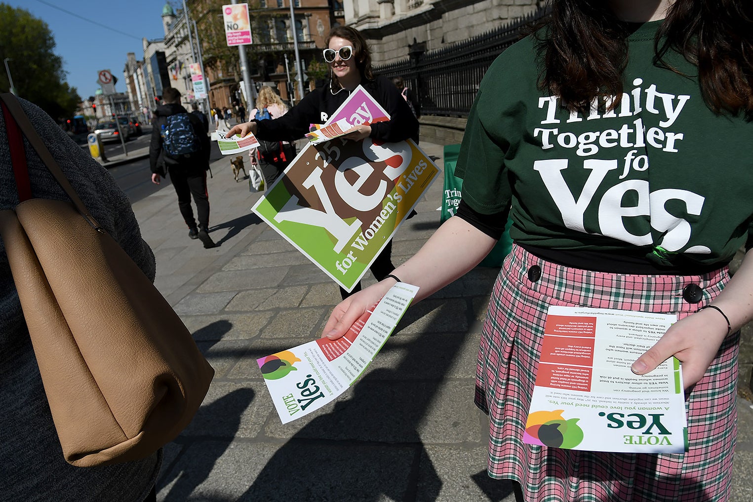Women handing out flyers and posters branded with the word "Yes!"