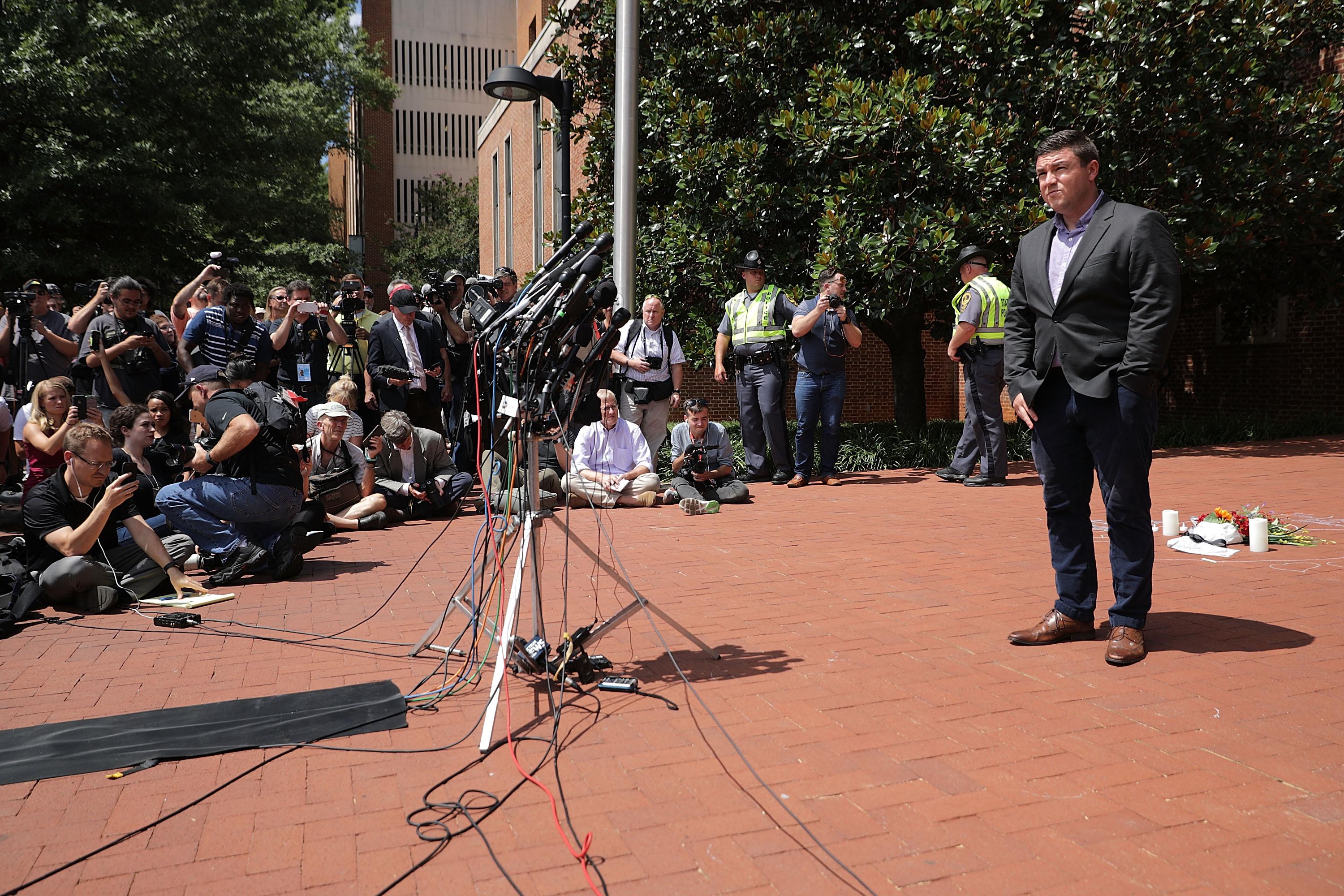 Jason Kessler stands in front of a crowd at a news conference.