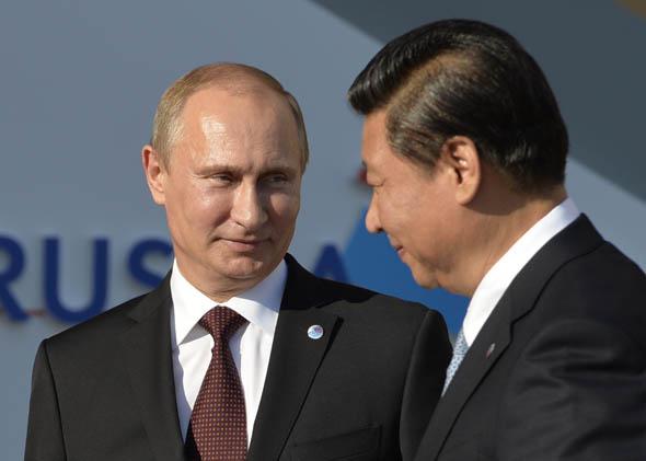 Russia's President Vladimir Putin (L) welcomes China's President Xi Jinping at the start of the G20 summit on September 5, 2013 in Saint Petersburg.