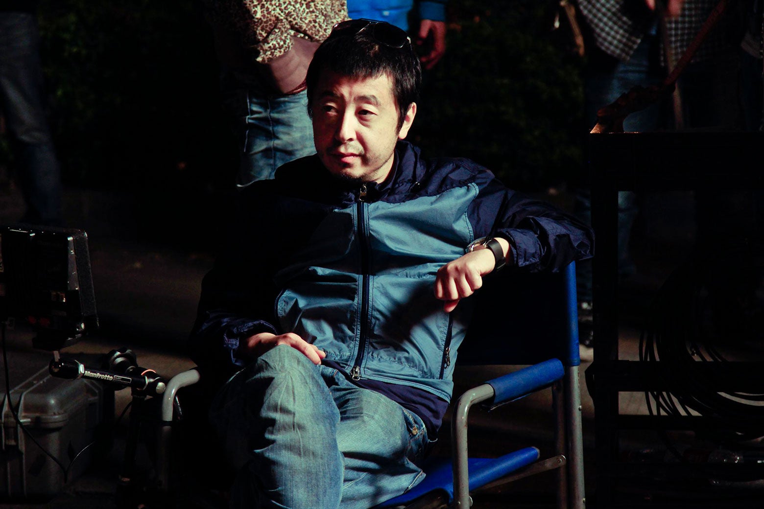 Director Jia Zhangke sitting in a director's chair.