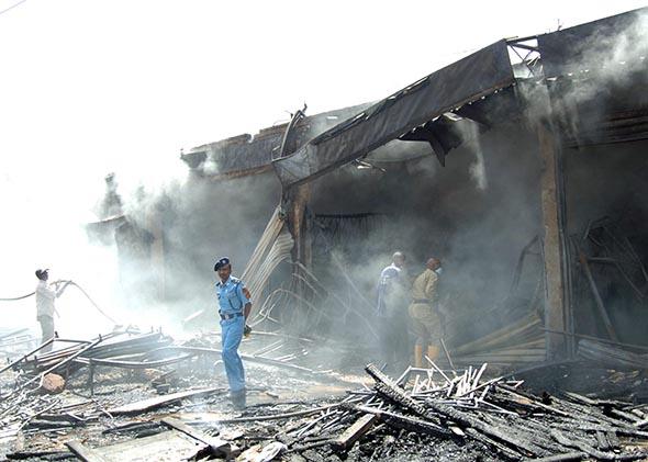 A civil defense officer inspects the scene of a fire at a popular market in the Sudanese capital Khartoum, on September 29, 2013.  