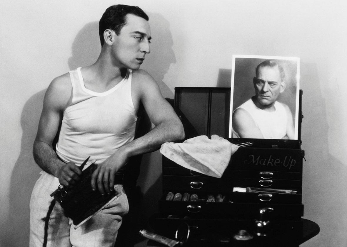 A gelatin silver print showing the silent comedian Buster Keaton looking at a photo of Lon Chaney.