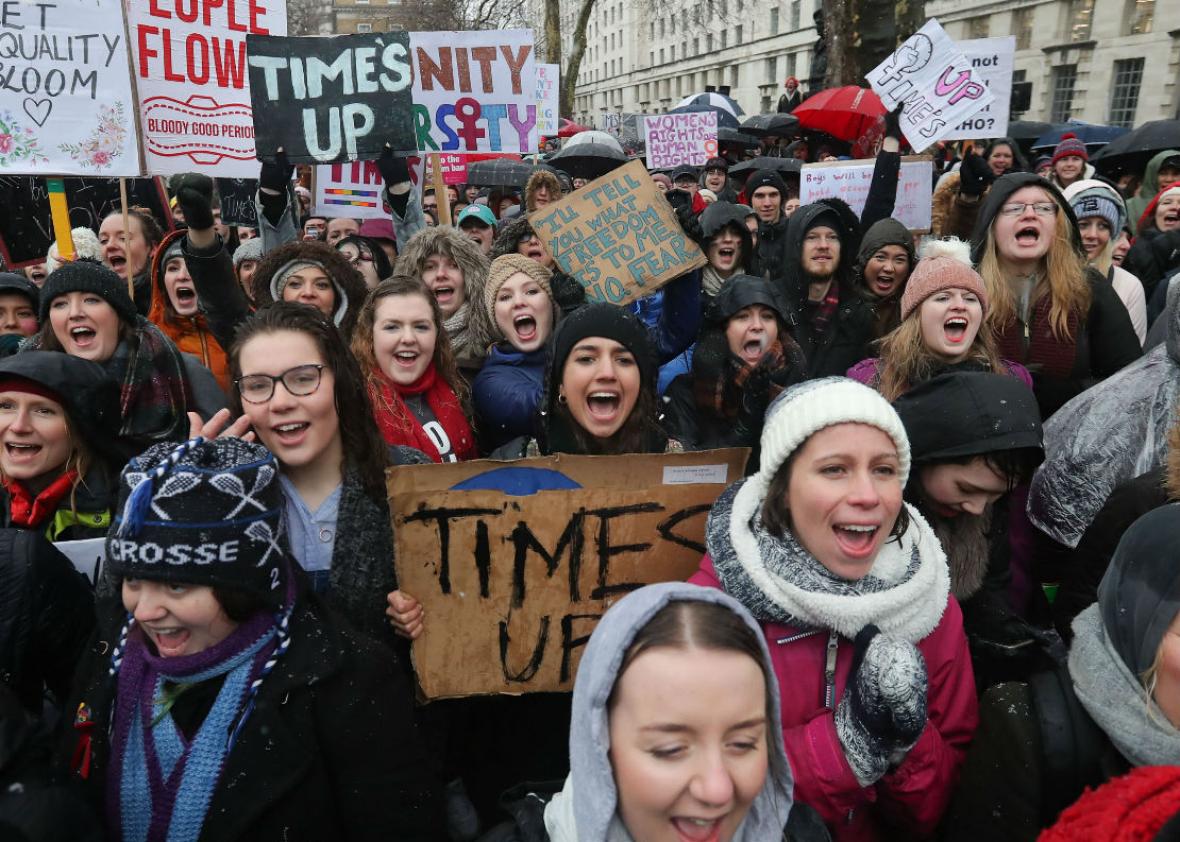 Protesters march, chant, and hold up signs with feminist slogans such as "Time's Up" and "Women's Rights Are Human Rights."
