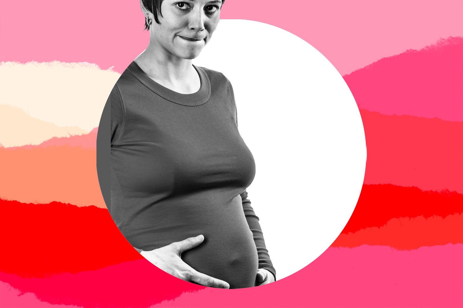 A pregnant woman looks worried while holding her belly.