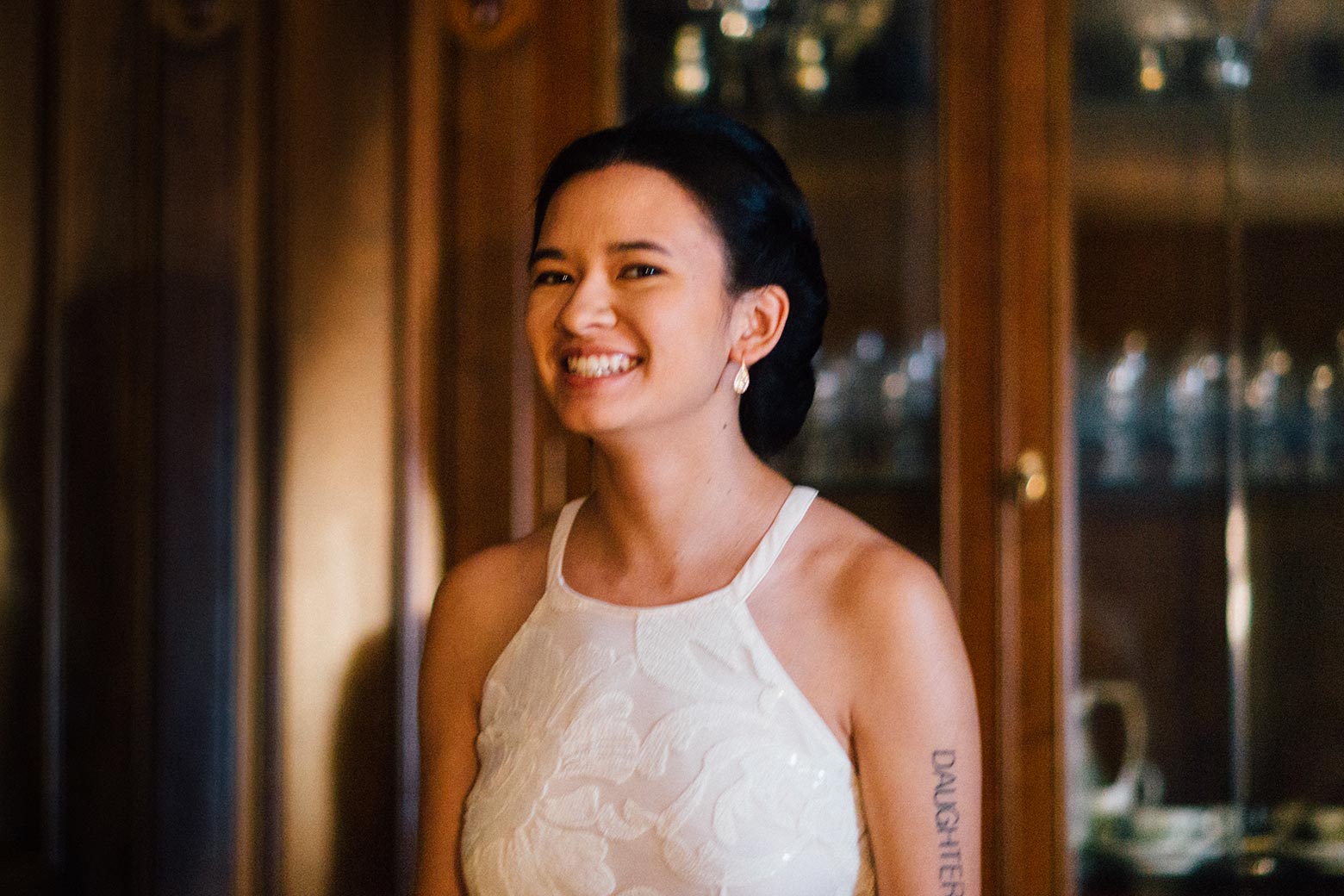 Alana Chen is pictured with a smile and the word "daughter" tattooed on her left arm.