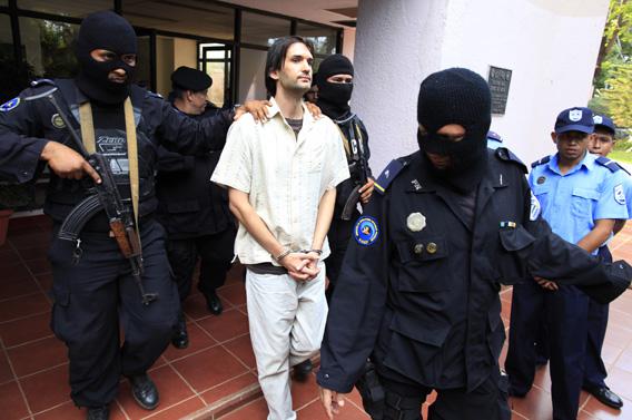 Eric Justin Toth of the U.S. is escorted after a presentation to the media at police headquarters building in Managua April 22, 2013.