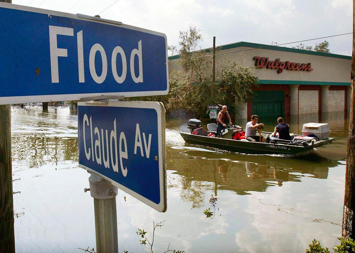 Men ride in a boat in high water past Flood Street after Hurrica